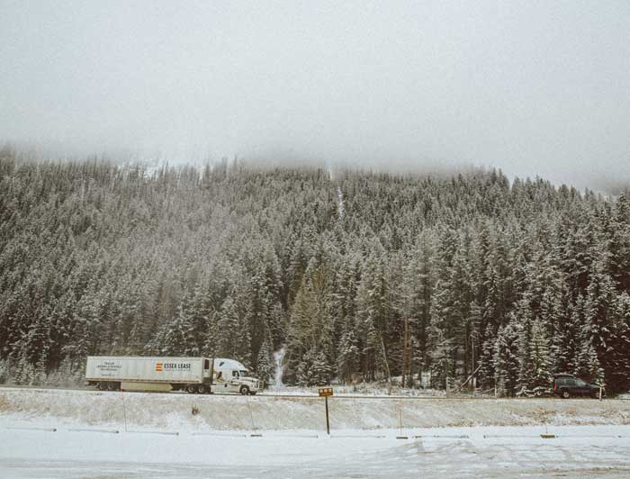 A truck driving down a snowy road.