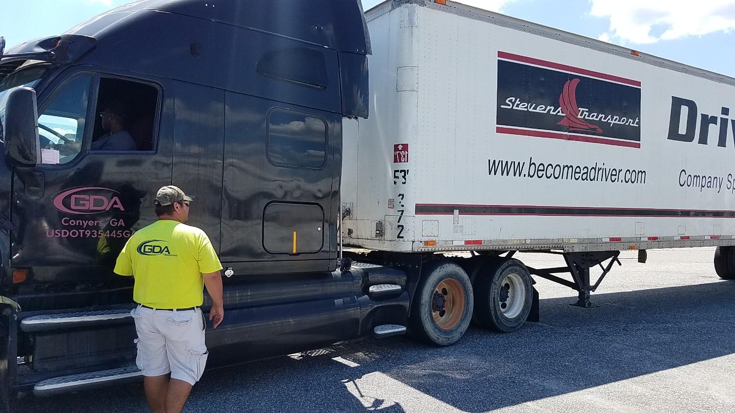 GDA instructor looking at GDA cab and Stevens Transport trailer