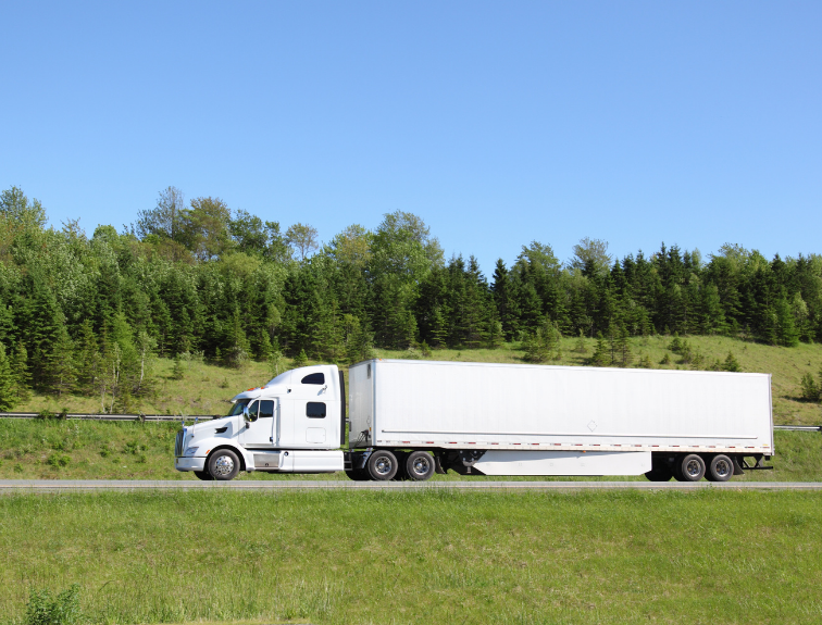 white semi and trailer driving on a sunny day