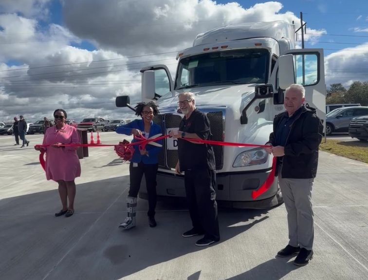 Team at GDA cutting ribbon in front of semi truck