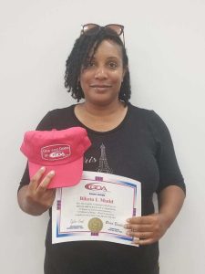 Female GDA graduate holding CDL certificate and GDA hat